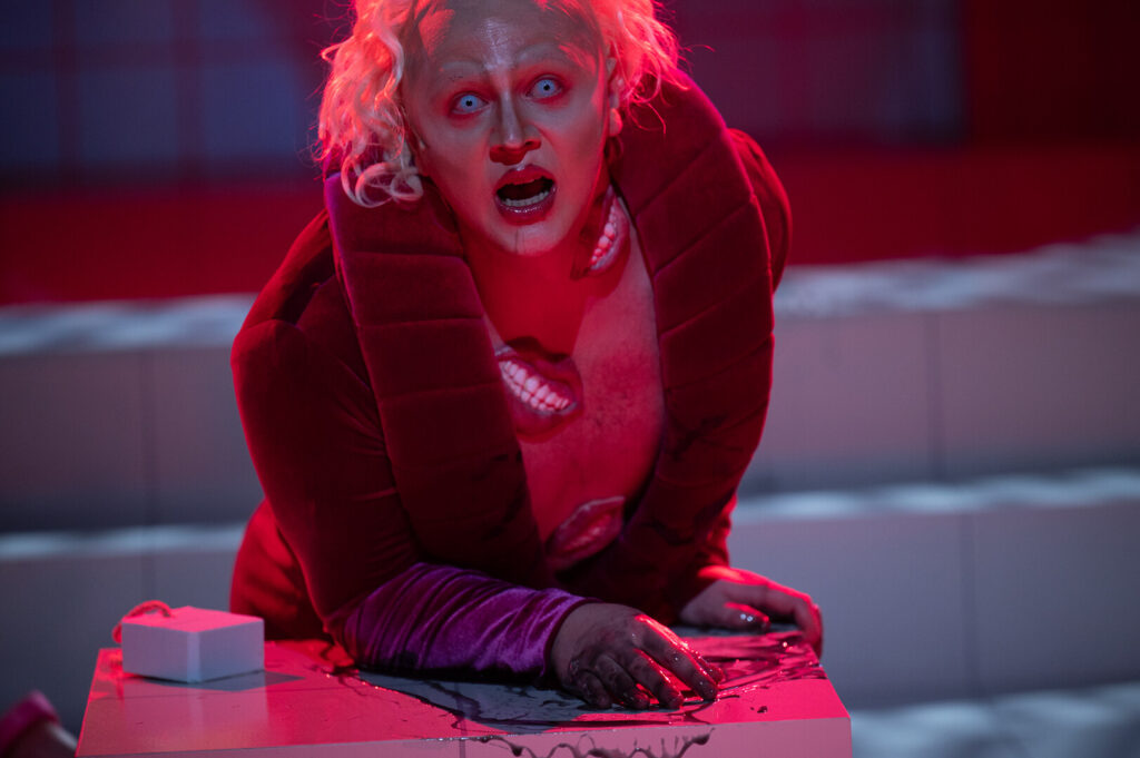 Szene aus dem Theaterstück „Pretty Privilege“ (Schauspiel Stuttgart): Felix Jordan als Henry kauert mit weitaufgerissenen Augen und Mund auf einem Sitzblock. (Foto: Björn Klein)