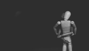 Vor schwarzem Hintergrund umschlingen sich zwei Holzpuppen, die Schaufensterfiguren ähneln. (Foto: Gaelle Marcel auf Unsplash)