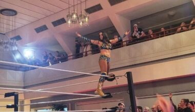 Die Wrestlerin Michelle Green steht mit ausgebreiteten Armen auf einem Ringpfosten, dem Publikum zugewandt. (Foto: vliestext)