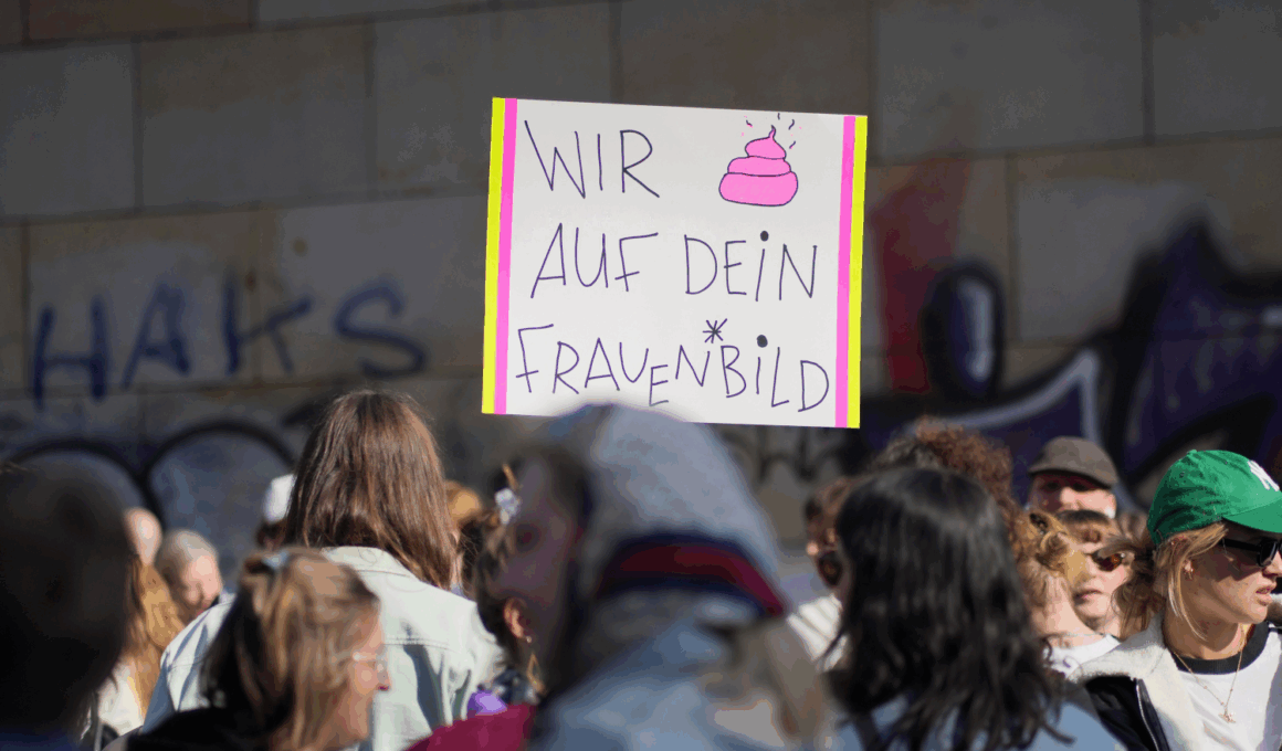 Foto einer Demo. Inmitten von weiblich lesbaren Menschen ist ein Plakat zu sehen, auf dem steht: Wir (Kothaufen-Emoji) auf dein Frauenbild.