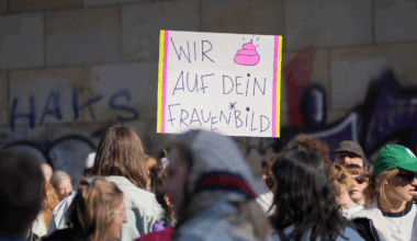 Foto einer Demo. Inmitten von weiblich lesbaren Menschen ist ein Plakat zu sehen, auf dem steht: Wir (Kothaufen-Emoji) auf dein Frauenbild.