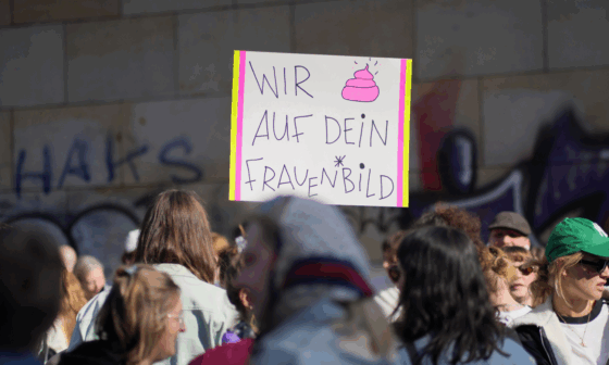 Foto einer Demo. Inmitten von weiblich lesbaren Menschen ist ein Plakat zu sehen, auf dem steht: Wir (Kothaufen-Emoji) auf dein Frauenbild.