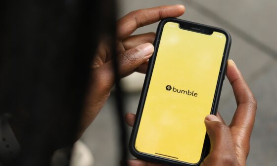 Schwarzer Mensch schaut auf Handy-Bildschirm, auf dem das gelbe Bumble-Logo zu sehen ist. (Bild: Good Faces Agency auf Unsplash)