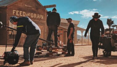 In den Kulissen einer Western-Stadt arbeitet eine Film-Crew mit ihrer Ausrüstung und bereitet eine Szene vor. Im Hintergrund blauer Himmel. (Bild: Chris Murray auf Unsplash)