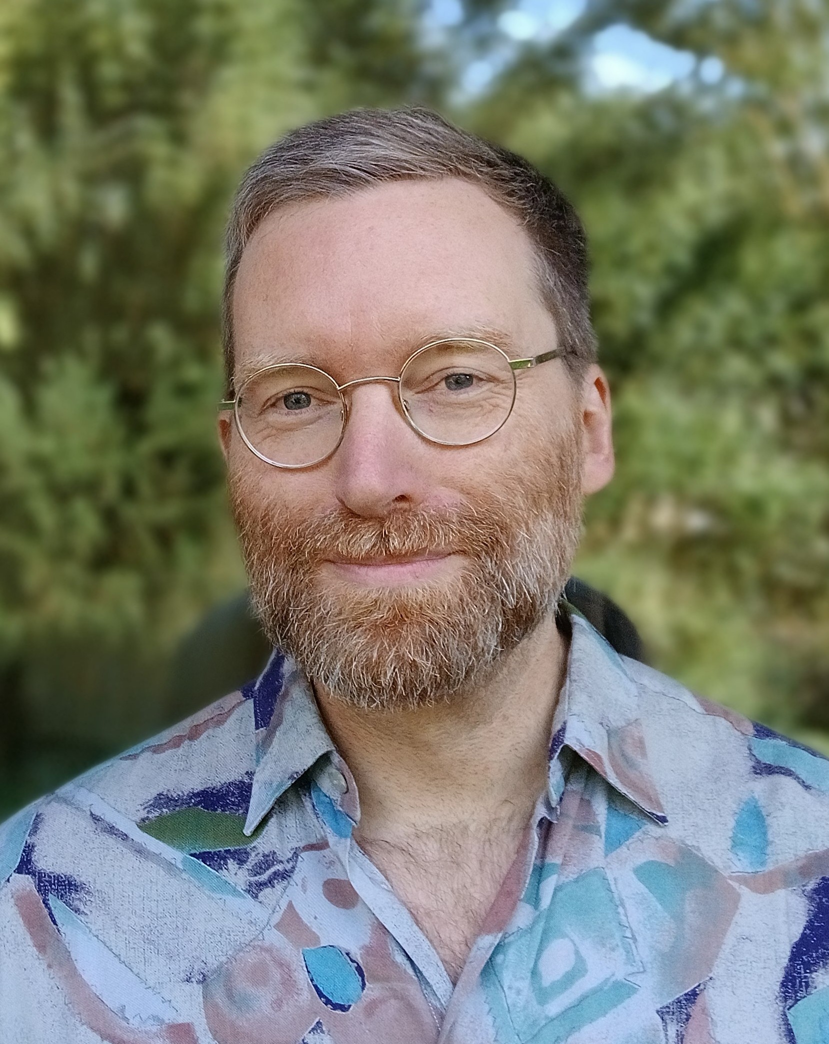 Mensch (Oliver Pöttgen) mit Vollbart, Brille und blauem Hemd. (Foto: vliestext)