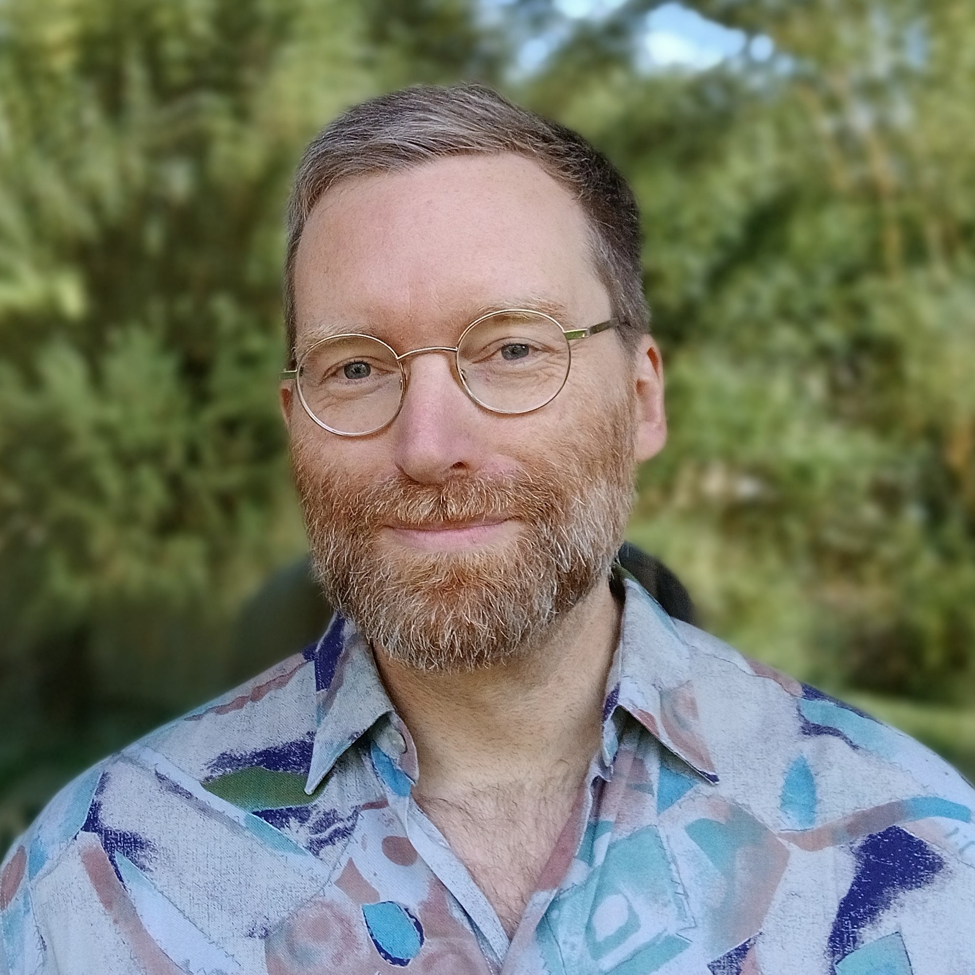 Mensch mit Vollbart, Brille und blauem Hemd. (Foto: vliestext)